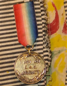 I’m a £.S.D. addict medal from Great Britain. £.S.D. means “pounds, shillings, pence” and thus means I’m a money addict.